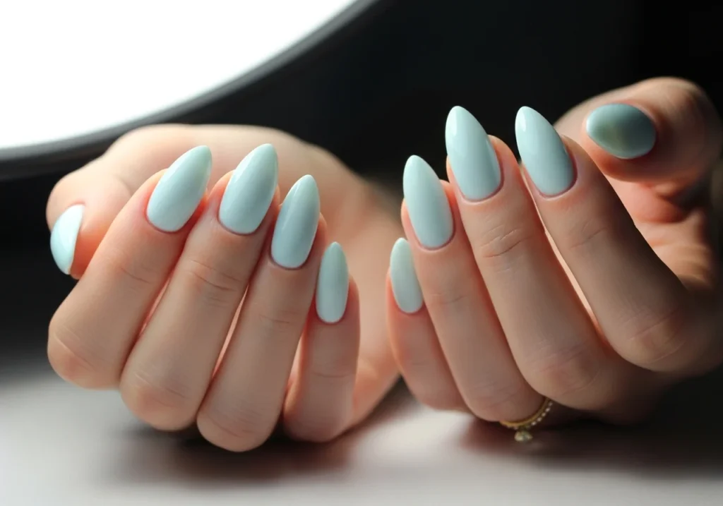 Close-up of soft milky light blue nails with a smooth glossy finish, offering a modern bridal manicure style