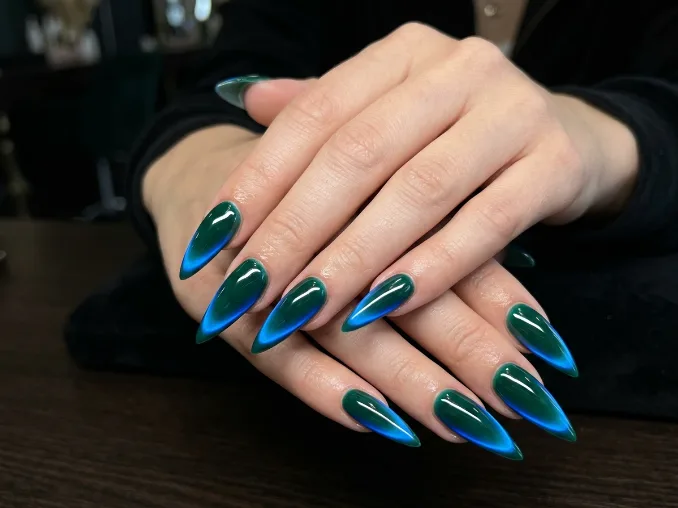 Deep emerald nails with an electric blue side glow