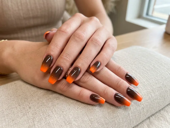 Espresso brown nails fading into vivid neon orange tips
